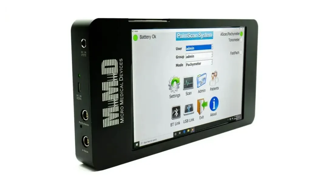 A black, rectangular handheld medical device from Micro Medical Devices displays a touchscreen interface with options like Settings, Scan, Admin, and Patients, showing it is ready for use.