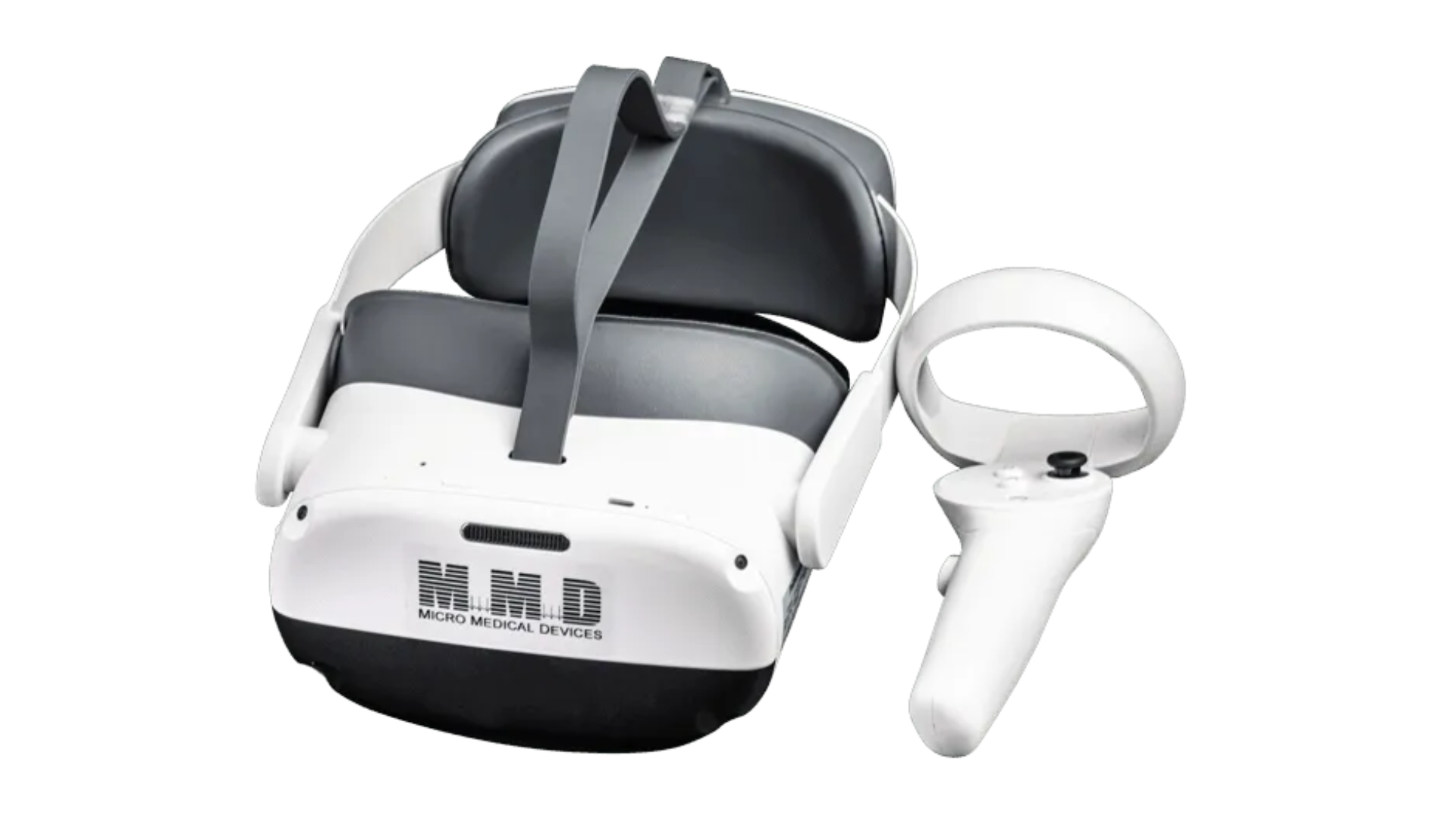 A white and gray virtual reality headset labeled Micro Medical Devices is shown with an attached head strap and a matching handheld controller placed beside it.
